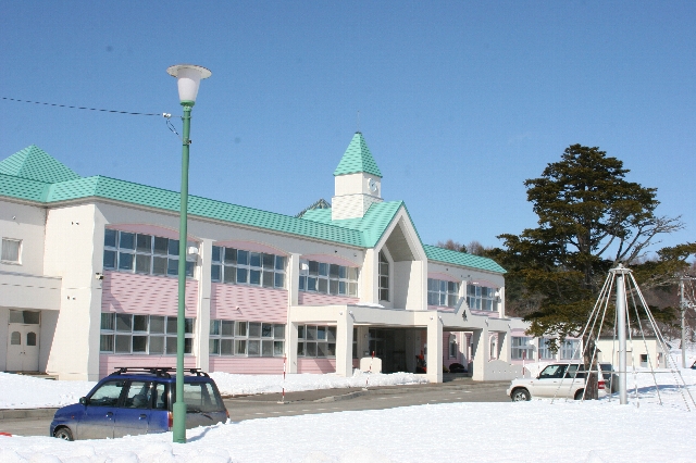 ミントグリーンの屋根とピンク色の壁の豊住交流センターの写真