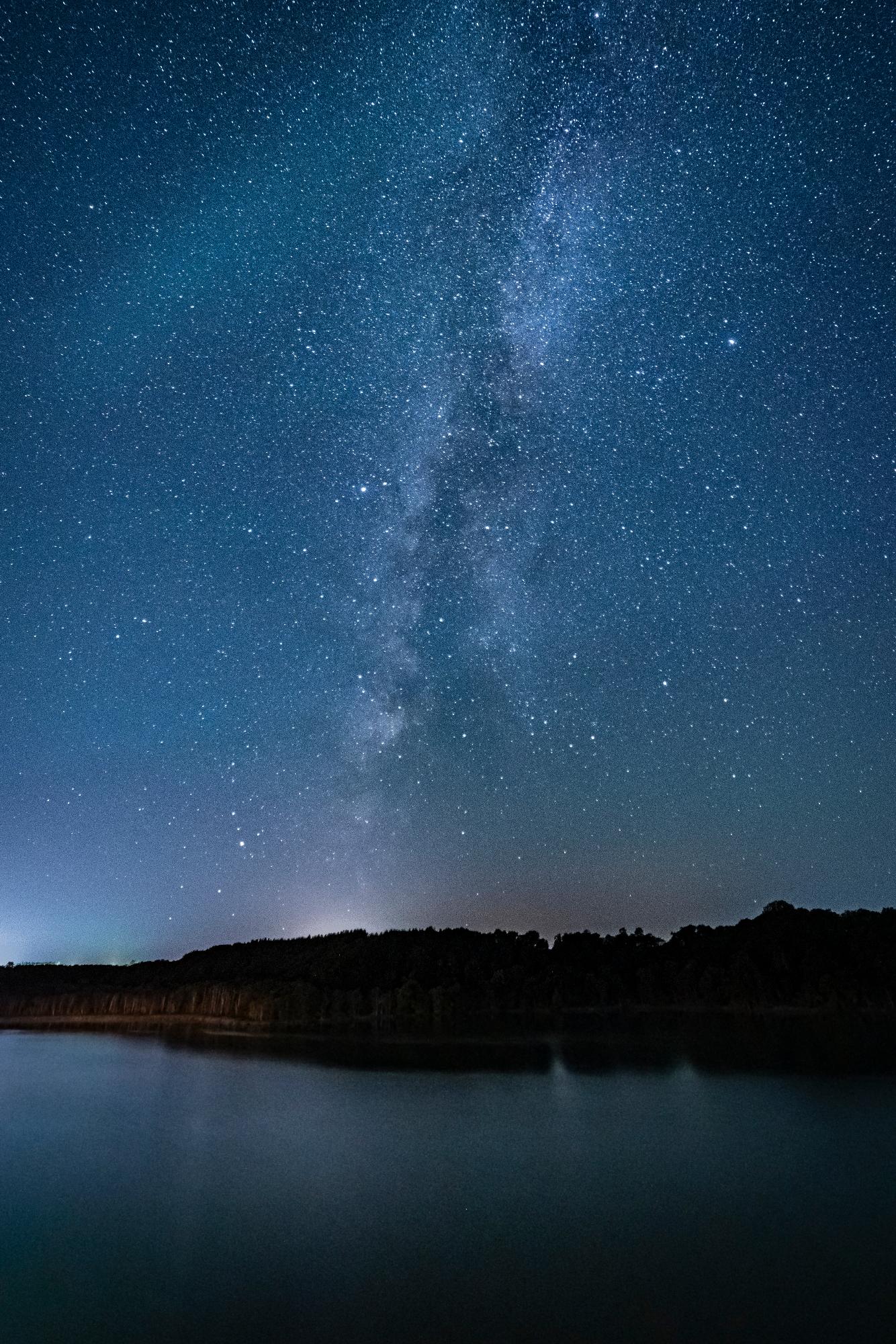 湖面の上空で星々が輝いている様子の写真