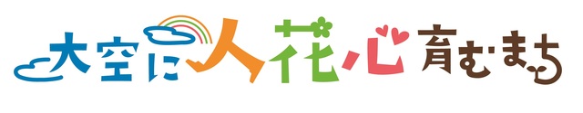 大空に人花心育むまちといろいろな色で書かれた文字