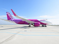 滑走路にピンクと白の機体の飛行機が止まっている写真