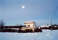 雪原に建っている赤い屋根の宿の写真