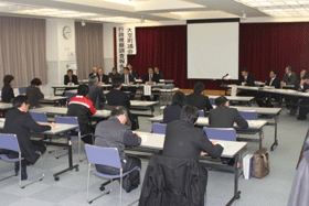長机の席に2人ずつ座り報告会に参加する町民と向かい合うように座る複数の関係者の写真