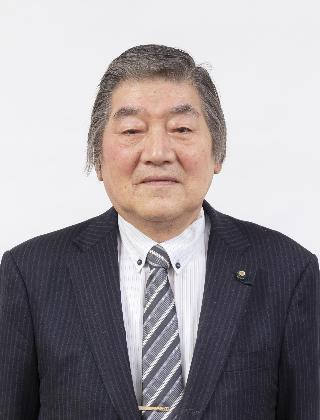 黒いスーツにストライプのネクタイをしめた深川昇さんが正面を向いている写真