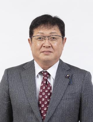 グレーのスーツにエンジ色のネクタイをしめてメガネをかけた福田淳一さんが正面を向いている写真