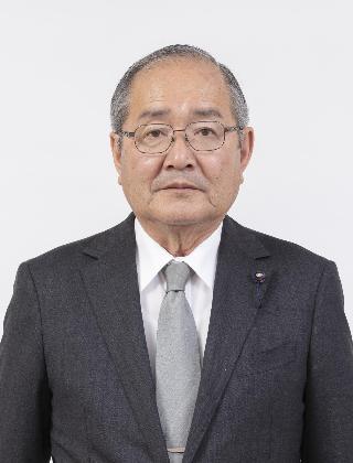 黒いスーツにグレーのネクタイをしめてメガネをかけた原本哲己さんが正面を向いている写真