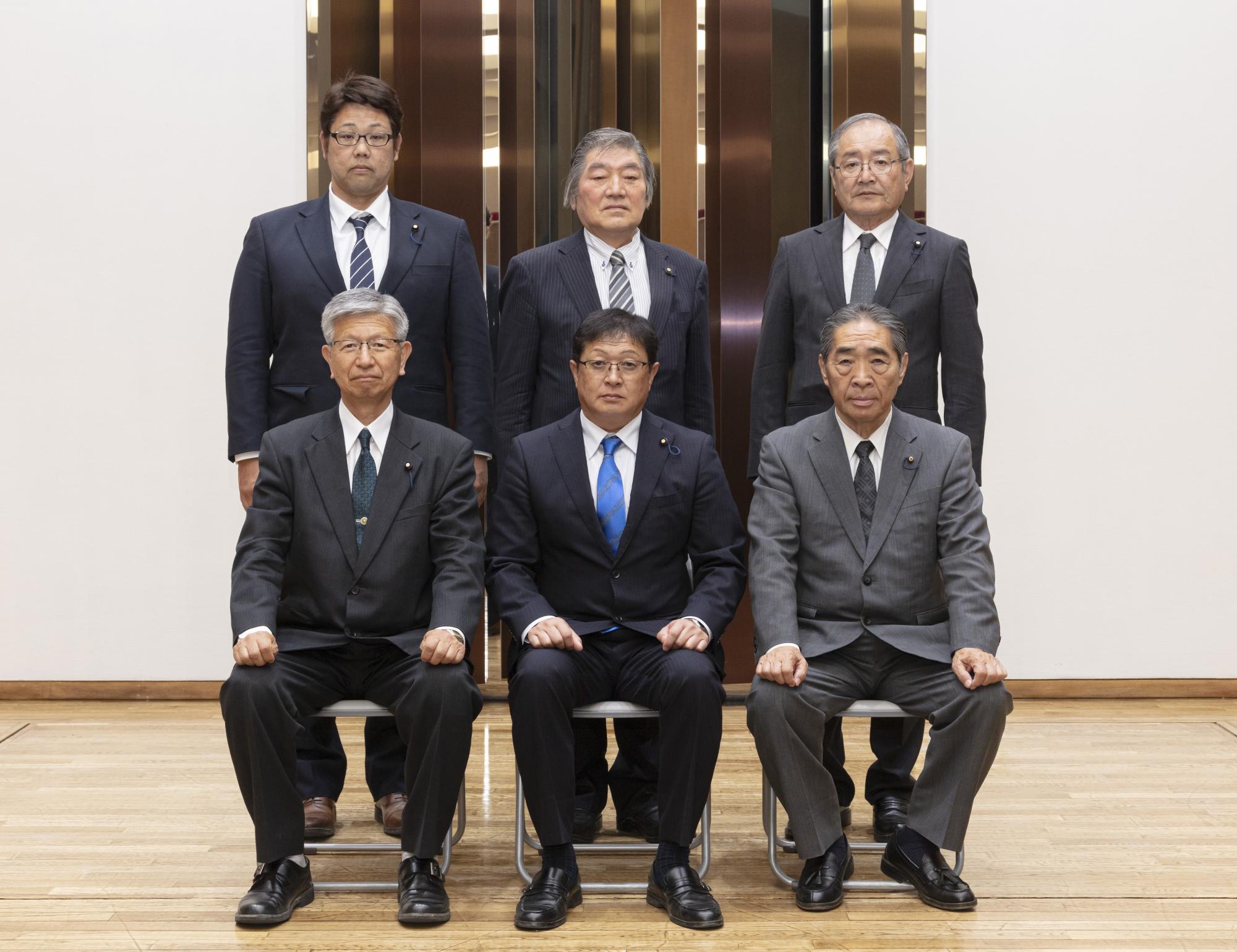 福田委員長を中心に、前3名が座り後ろ3名が立ち正面を向いている写真