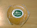 ビニール袋で密封された半球型のスモークゴーダチーズの写真
