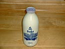 青地のラベルで装飾されたひがしもこと牛乳の牛乳瓶の写真