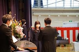 校長先生から卒業証書を差し出されている女子卒業生の写真