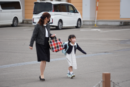 母親と一緒に登園している新一年生の女の子の写真