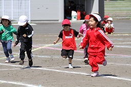 赤い帽子や白い帽子をかぶった5人の児童が駆け寄ってきている様子の写真