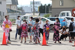 浴衣姿の女の子たちが赤い三角コーンの近くに集まっている様子の写真