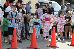 赤い三角コーンの前に集まっている浴衣姿の子どもたちの写真