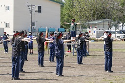 準備運動をしている赤いはちまきをしている中学生たちの写真