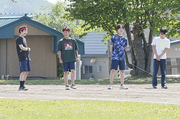 赤いはちまきをしている男子中学生2人と白いはちまきをしている男子中学生2人がスタートラインに立っている写真