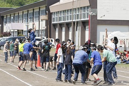 白いはちまきをしている中学生たちのが玉入れをしている写真