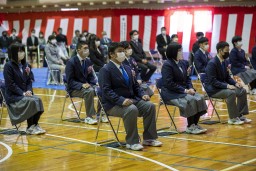 卒業生たちがパイプ椅子に座って話を聞いている様子の写真