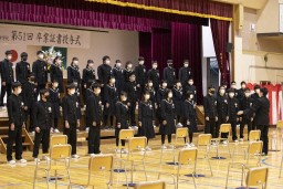 指揮に合わせて合唱をしている様子の卒業生たちの写真