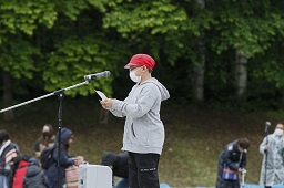 マイクの前で選手宣誓をしている赤い帽子の男子小学生の写真
