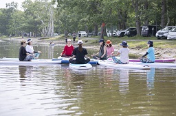 湖上で8人の参加者がボードの上で座っている写真