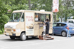 すがのおやきと看板が出ている移動販売車にお客さんが着ている写真