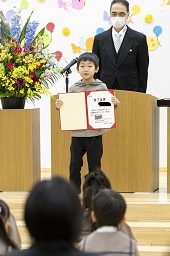 壇上で卒園証書を開いて披露している卒園児童の写真その3