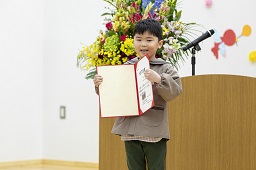 壇上で卒園証書を披露している男の子の写真