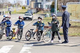 自転車を降りて横断歩道を手押ししている小学生たちの写真