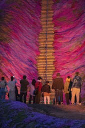 ライトアップされている木でできた階段を見上げている観光客の様子の写真