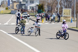 自転車を降りて手押ししている3人の小学生たちの写真