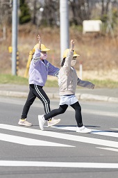 女子小学生の2人が横断歩道を歩いている様子の写真