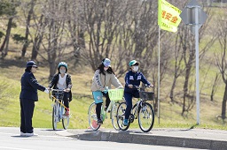 自転車に乗っている小学生が一時停止をしている様子の写真