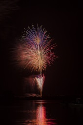 闇夜に赤い打ち上げ花火が連続で咲いている様子の写真