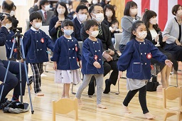 紅白幕が掛けられた会場に入場してくる卒園児たちの写真その2