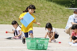 グラウンドで障害物レースに挑んでいる4人の女児の写真