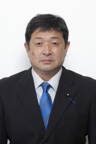 黒いスーツに明るいブルーのネクタイをしめた福田淳一さんが正面を向いている写真