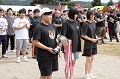 黒いTシャツの女性チームに、トロフィーと賞状が授与されている写真