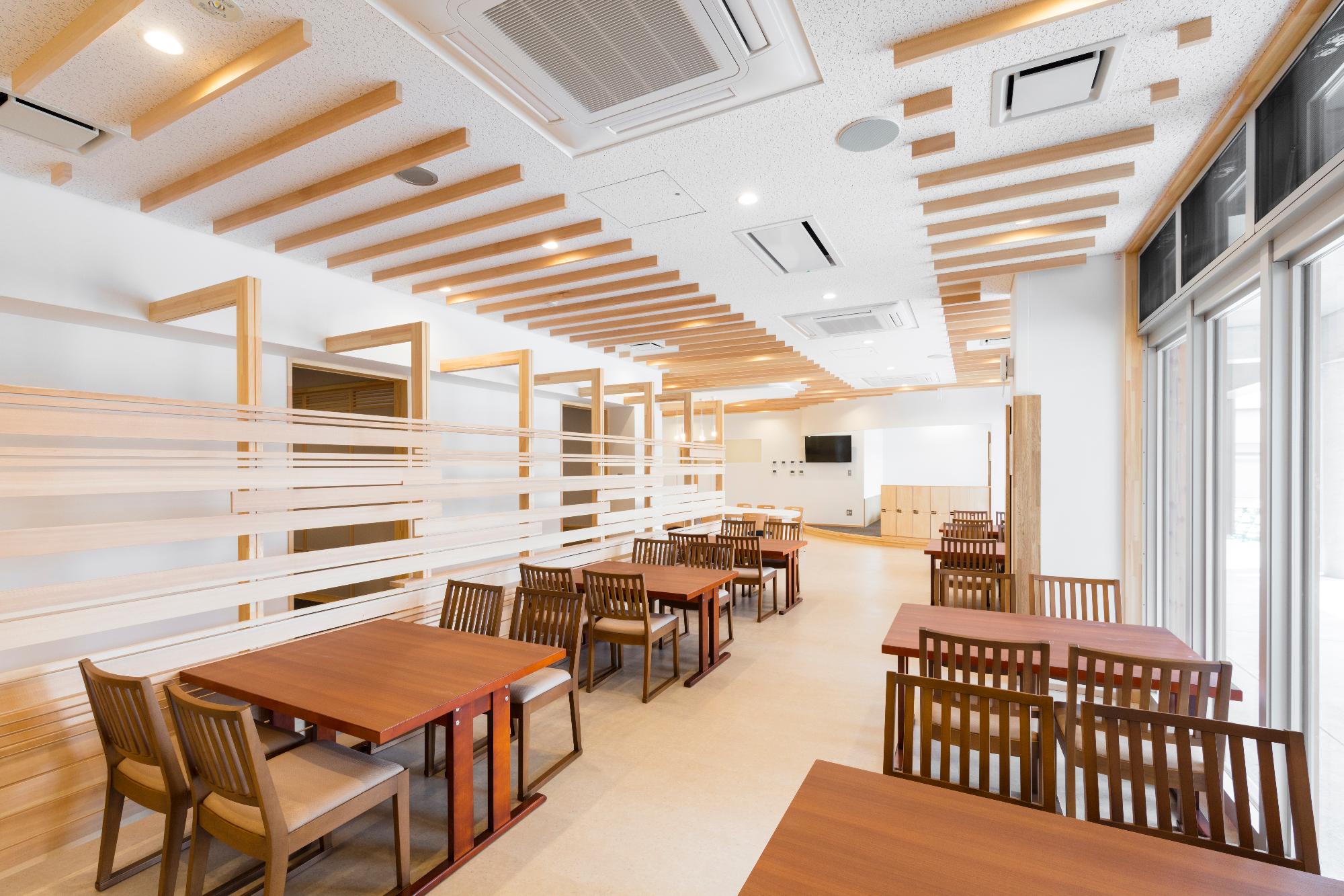 明るい空間に木製の椅子とテーブルが複数台並んでいる屋内のレストラン「くるりんく」の写真