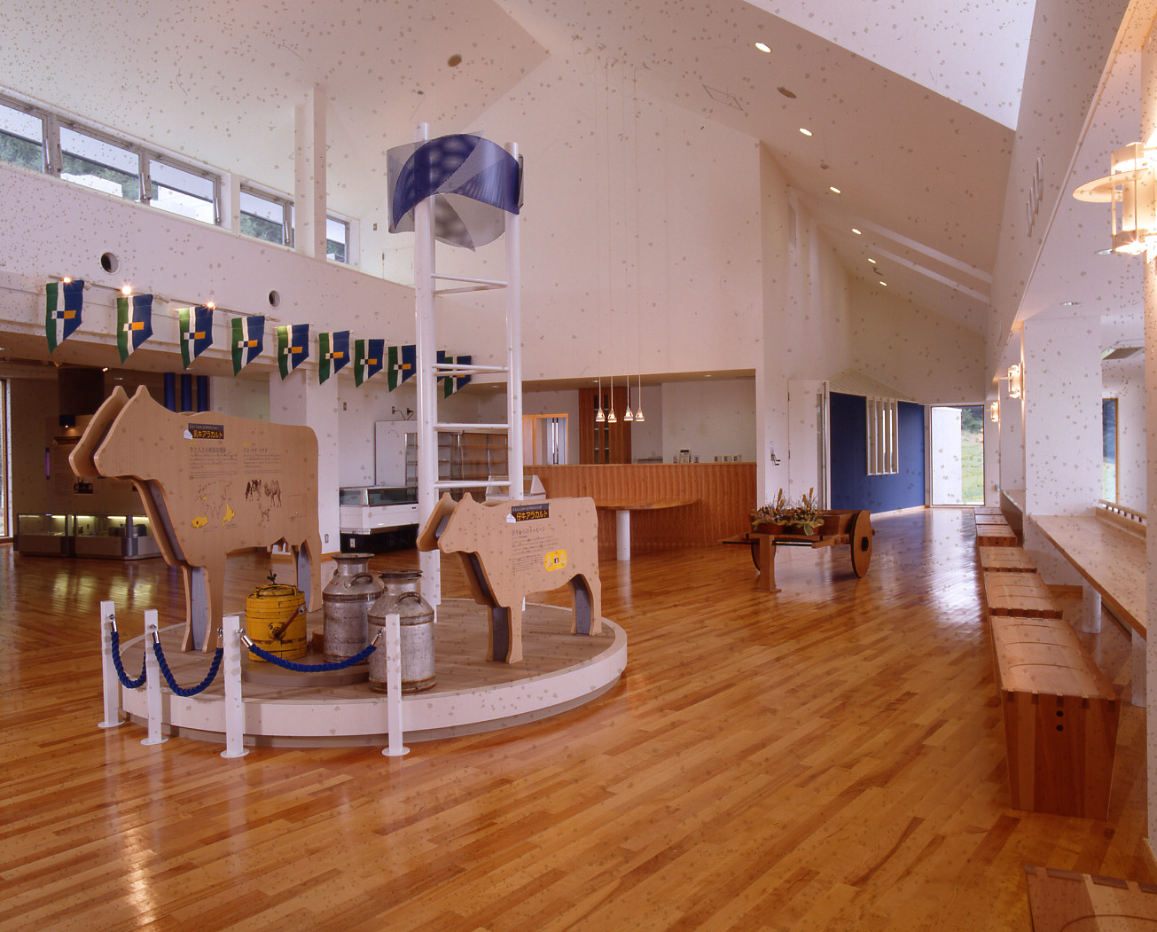吹き抜けの高い天井の広々とした展示室に設置されている、牛の形をした大小2つの立体パネルの写真